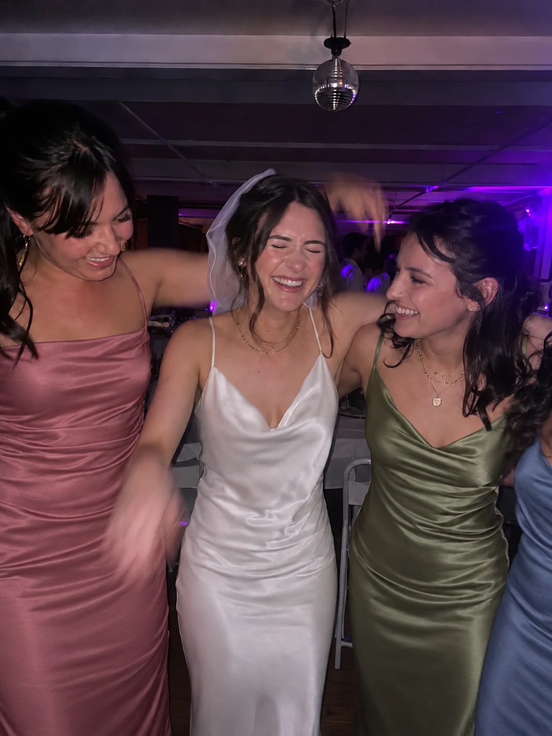Friends laughing on a wedding dance floor